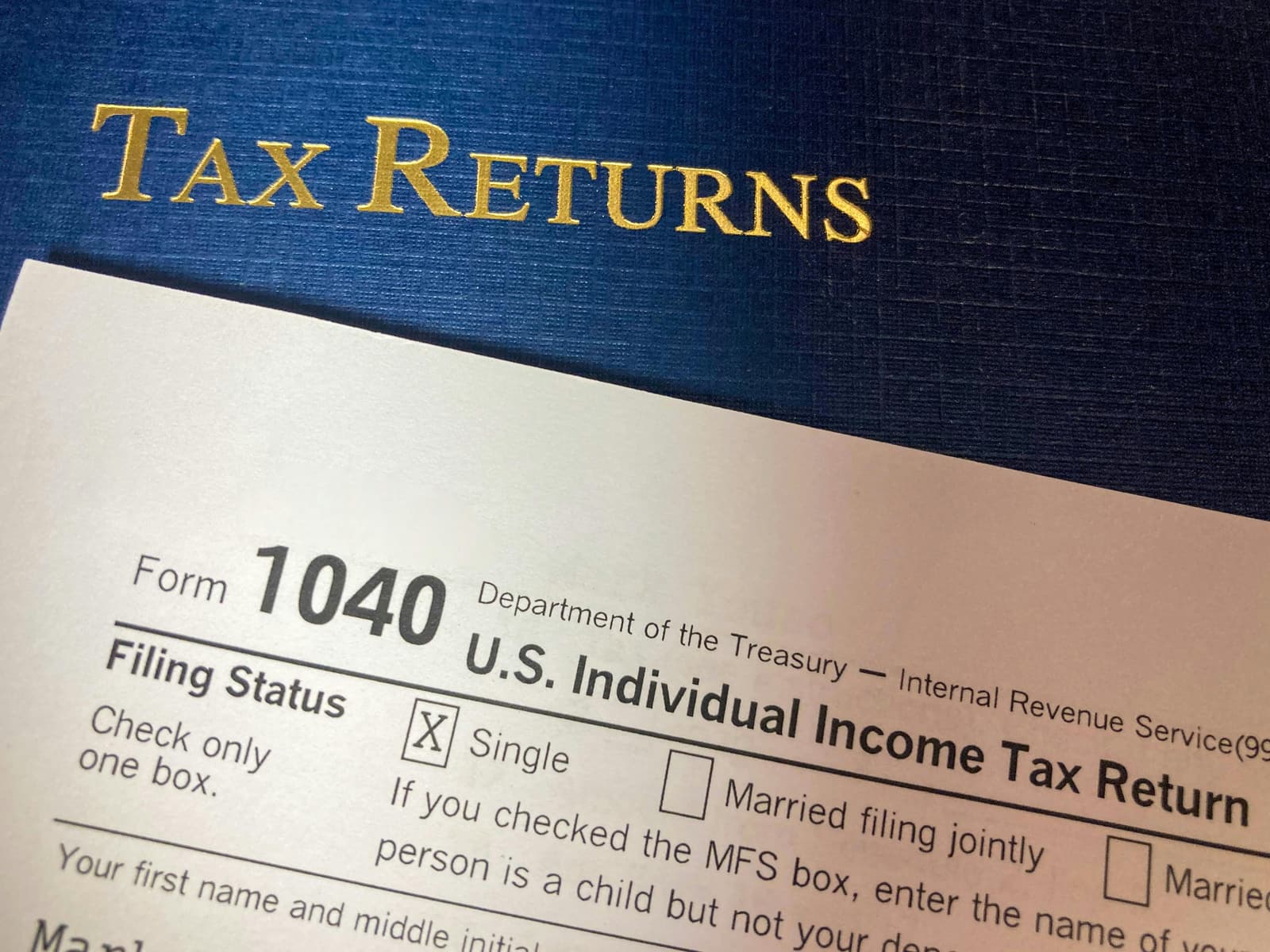 A federal Form 1040 beside a Tax Returns folder